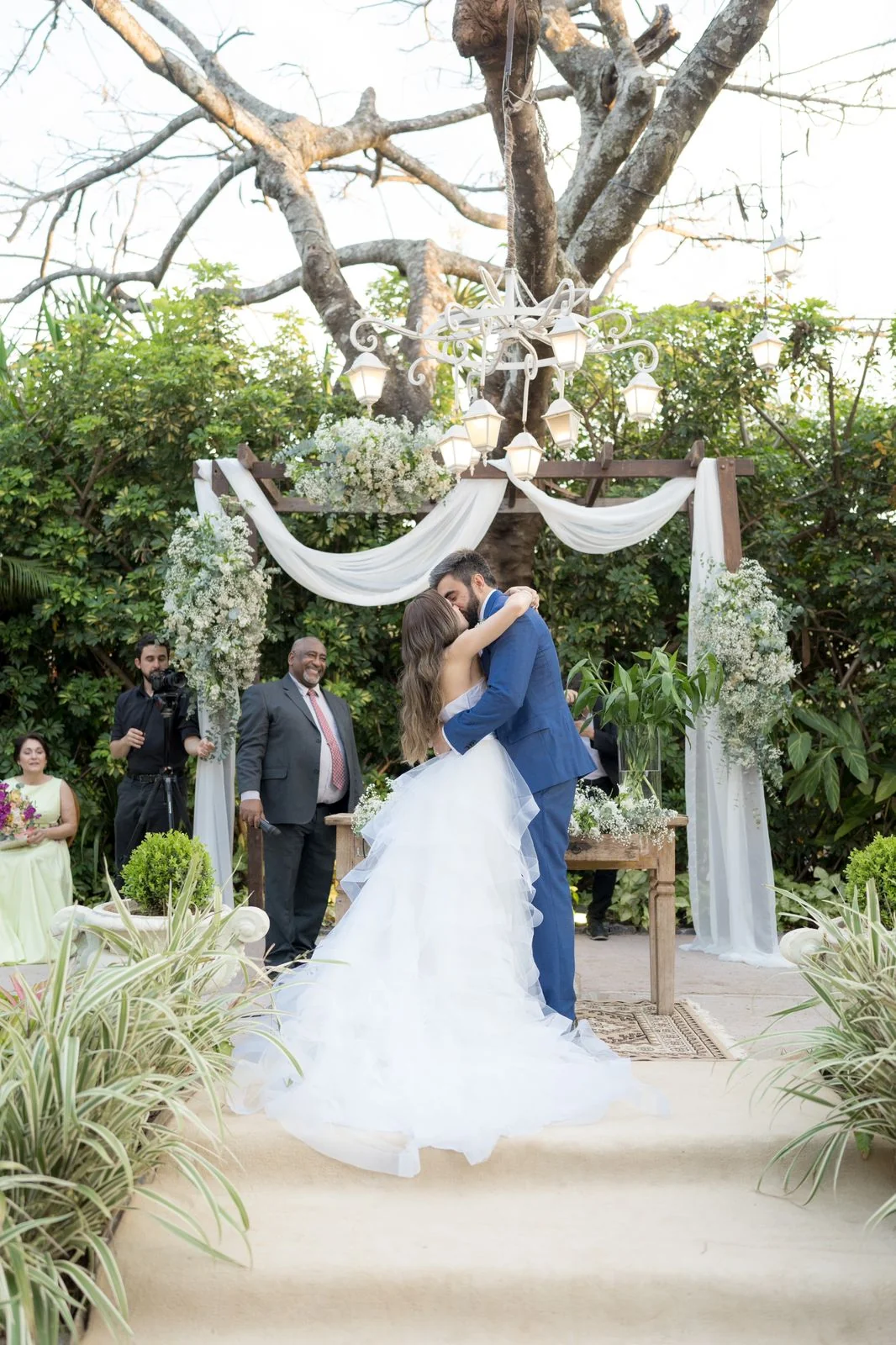 Celebrante e casal em cerimônia ao ar livre